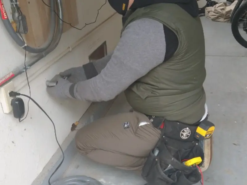Electrician performing outlet wiring in a David City garage